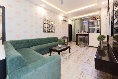 a living room with a green couch and a table at Hotel CASA Aishbagh in Lucknow