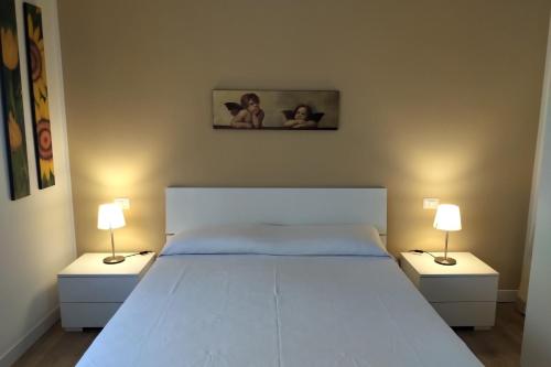 ein Schlafzimmer mit einem großen weißen Bett mit zwei Nachttischen in der Unterkunft CARMEN E FEDE in Giardini-Naxos
