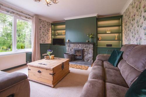 sala de estar con sofá y chimenea en Calm Scottish Country Escape with Hot Tub Sleeps 6 en Inverness