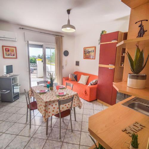 a kitchen and living room with a table and a couch at Salento Delizioso appartamento con ampia corte in Torre San Giovanni Ugento