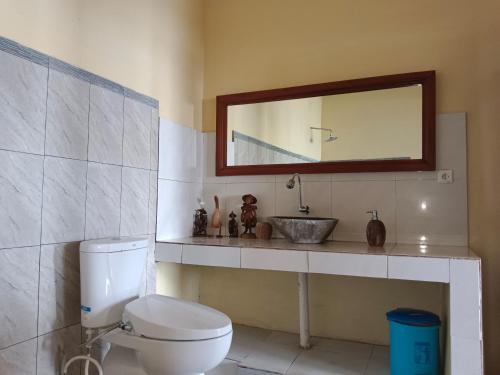 ein Badezimmer mit einem WC, einem Waschbecken und einem Spiegel in der Unterkunft beach side Amed Delem family in Ambat