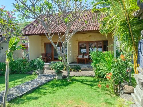 a house with a garden in front of it at beach side Amed Delem family in Amed