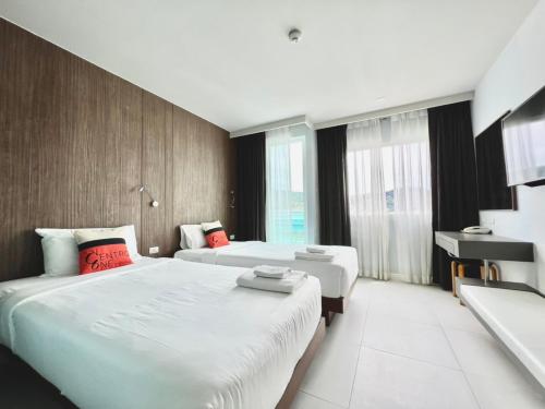 a hotel room with two beds and a desk at Centro One Patong in Patong Beach