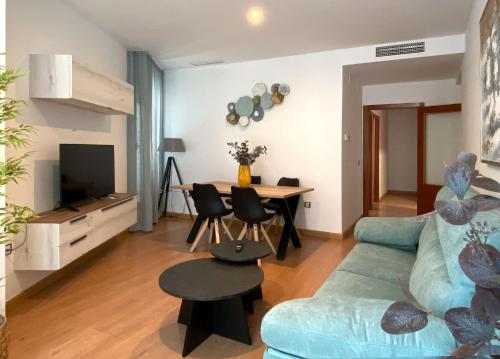 a living room with a blue couch and a table at Gran Hotel Don Manuel in Cáceres
