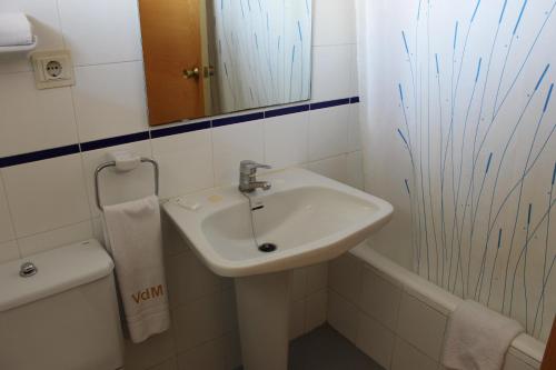 a bathroom with a sink and a toilet and a mirror at Apartamentos Viña del Mar in Benidorm