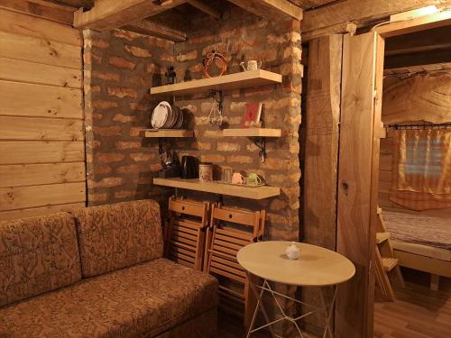 a room with a couch and a table in a cabin at Brvnara u planini in Petrovac na Mlavi