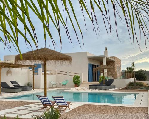 Villa con piscina con sillas y sombrillas. en Villa privada en entorno rural, en Cartagena