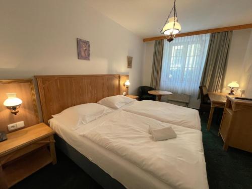 a hotel room with a bed and a table at Hotel Ennius in Klatovy