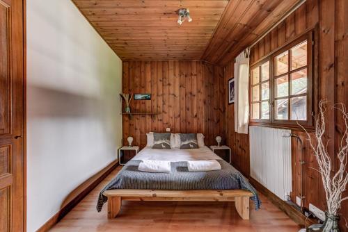 une chambre avec un lit et un plafond en bois dans l'établissement CHALET Trois Bois - Alpes Travel - LES HOUCHES - sleeps 8, aux Houches