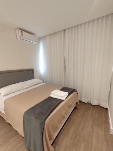a hotel room with a bed and a window at Apart Hotel - Campos dos Goytacazes in Campos dos Goytacazes