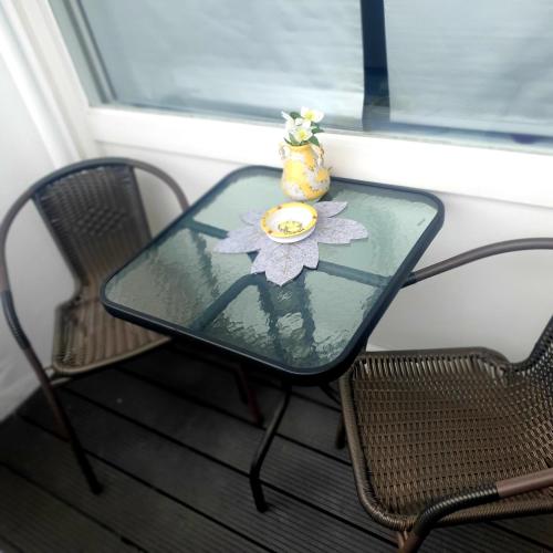 a glass table with a vase and two chairs at CrisAnd 3 Panoramic in Altenau
