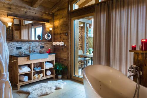 a bathroom with a tub in a room with wooden walls at Bayerischer Wald Chalets in Zwiesel
