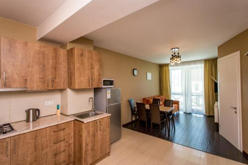 a kitchen with wooden cabinets and a dining room at Bakuriani Residence in Bakuriani