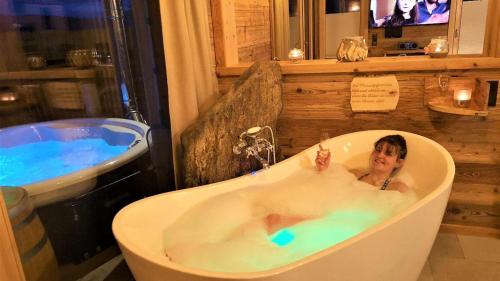 a woman in a bath tub in a bathroom at Bayerischer Wald Chalets in Zwiesel