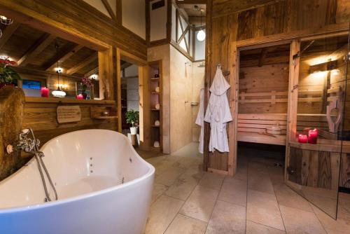 a bath tub in a bathroom with wooden walls at Bayerischer Wald Chalets in Zwiesel