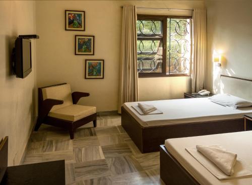 En eller flere senge i et værelse på Atithi Guest House