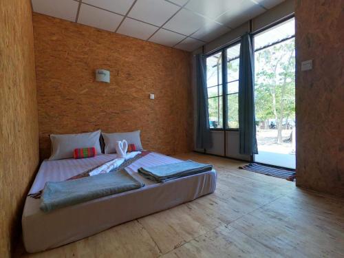 ein großes Bett in einem Zimmer mit einem großen Fenster in der Unterkunft Koh Ngai Sea Open Resort in Ko Ngai