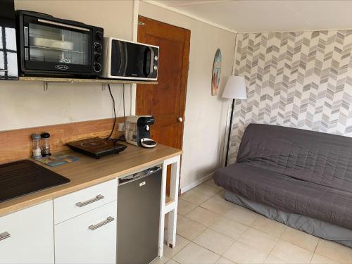 Cette petite chambre comprend un lit et un four micro-ondes. dans l'établissement Petite maison, quartier calme., à Bourges