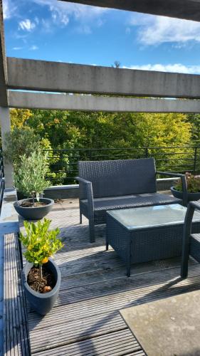 a patio with two benches and a table on a deck at Meerblick in Glücksburg