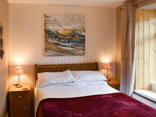 ウィンダミアにあるSlate Cottageのベッドルーム1室(ベッド1台、ナイトスタンド2台、ランプ2つ付)