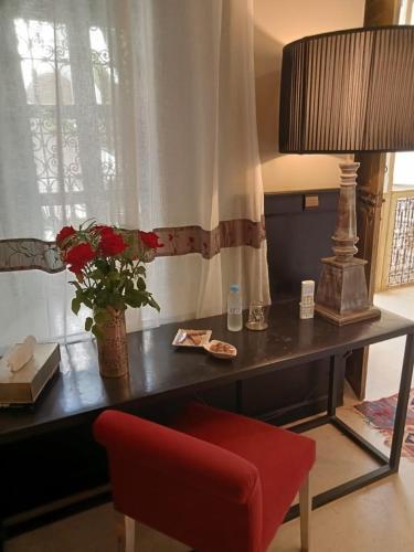 ein Schreibtisch mit einem roten Stuhl und einer Lampe in der Unterkunft Dar al Sultan in Marrakesch