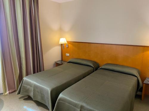 ein Hotelzimmer mit 2 Betten in einem Zimmer in der Unterkunft Hostal Meson Pepa in Logroño