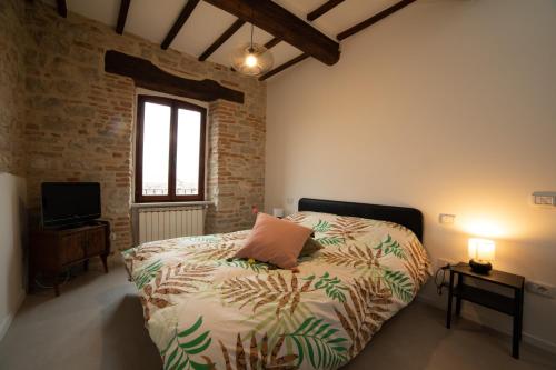 een slaapkamer met een bed met een kussen erop bij Appartamento centro storico Gubbio in Gubbio