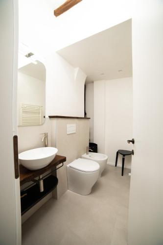 a white bathroom with a toilet and a sink at Appartamento centro storico Gubbio in Gubbio