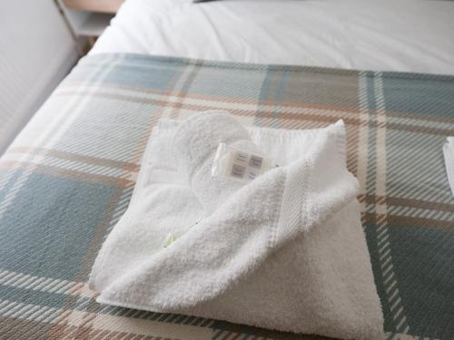 stos ręczników na łóżku w obiekcie Pass the Keys Beautiful Unique 3Bed Mews Cottage House w Glasgow