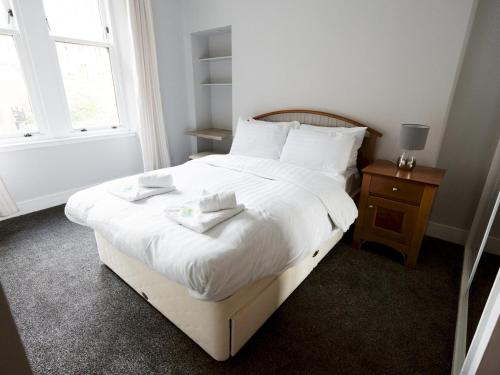 a bedroom with a white bed with two towels on it at Pass the Keys Superb 1Bed Flat in Fabulous West End in Glasgow