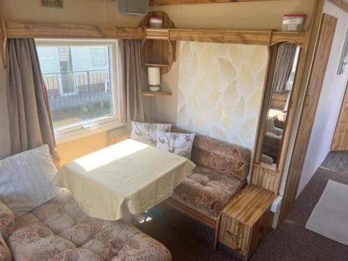 a room with a bed and a couch and a table at Castaway retreats 4 C34 in Lincolnshire