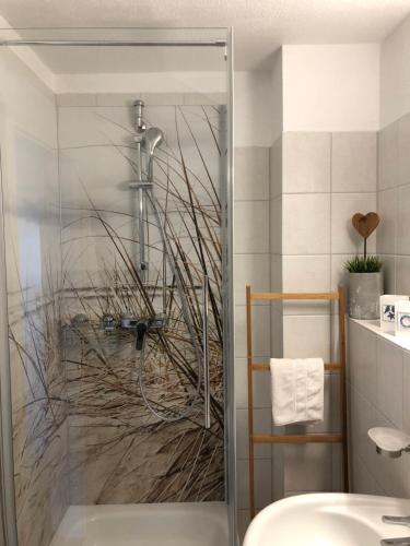 ein Bad mit einer Dusche und einem Waschbecken in der Unterkunft FeWo Sonnenblume Achtern Diek in Zingst