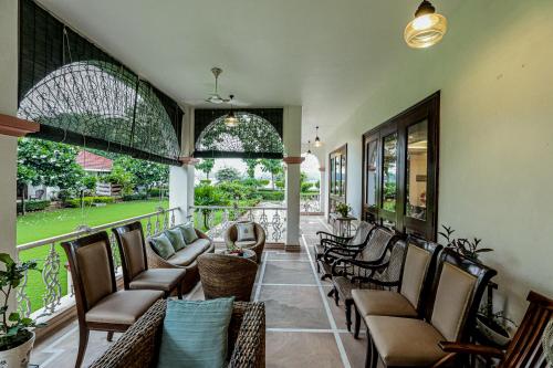 a living room with chairs and a porch at Saptapuri by Royal Orchid Hotels Limited Varanasi in Varanasi