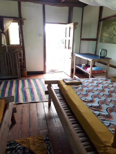 un soggiorno con letto e tappeto di ZIONZURI ARTS ECOVILAGE TREE HOUSE a Mbwamaji