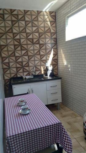 uma cozinha com uma mesa com uma toalha de mesa xadrez em hospedagem recanto do sábia 3 em Alto Caparaó