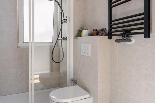 a bathroom with a shower and a toilet and a window at Alex & Rine - Pension Zum Alten Strom in Warnemünde