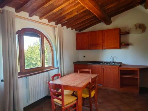 a kitchen with a wooden table and a window at Agriturismo Fattoria Lischeto in Volterra