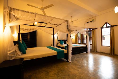 a bedroom with two beds in a room at International Beach Hotel & Restaurant in Hikkaduwa