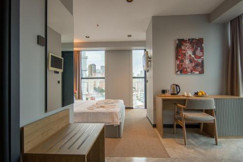 イスタンブールにあるSHERLOCK HOMES HOTELSのベッド、デスク、テーブルが備わる客室です。