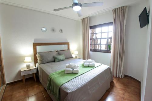 a bedroom with a bed with two towels on it at Paradise Gardens - Golf del Sur in San Miguel de Abona