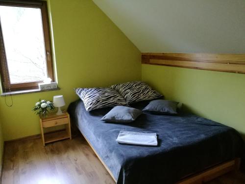 um quarto com uma cama com um edredão azul e uma janela em Domek w Zawoi Chwilo Trwaj em Zawoja