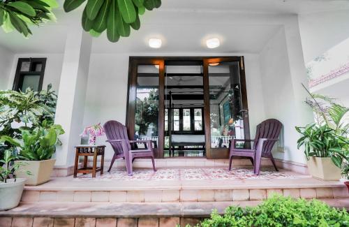 a porch with two chairs and a table at Saptapuri by Royal Orchid Hotels Limited Varanasi in Varanasi