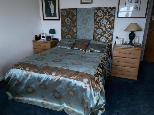 a bedroom with a bed and two dressers and a bedspread at Pagham Getaways in Pagham