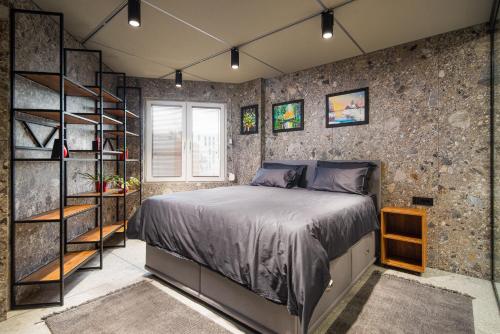 a bedroom with a bed and a stone wall at Apartment House - Delta in Sofia