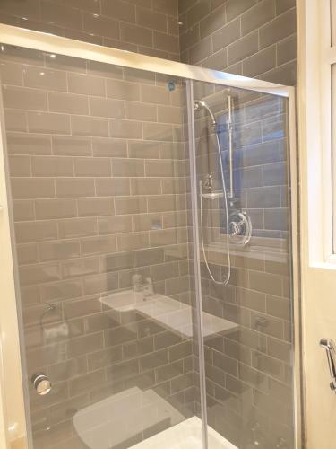 baño con ducha y puerta de cristal en London Luxury Spacious 2 Bedroom Apartment 4 mins from Ilford Stn. FREE parking, en Londres