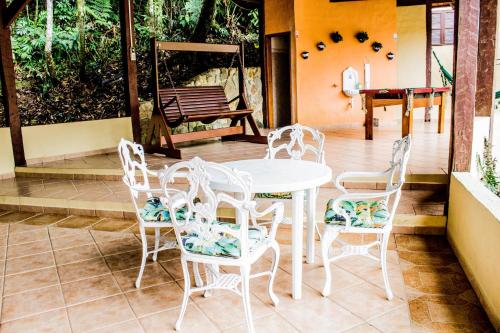 咎凱的住宿－Pousada Recanto dos Tangaras，庭院里的白色桌椅