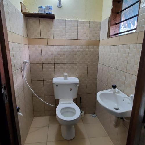 a bathroom with a toilet and a sink at 3 Bed Villa - Sleeps 6 - Wifi - Parking in Galu