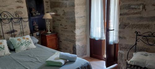 1 dormitorio con 1 cama con toallas en Casa Maruja, Puebla de Sanabria en Puebla de Sanabria