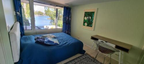 - une chambre avec un lit bleu et une fenêtre dans l'établissement Gorgeous apartment by the sea, à Helsinki