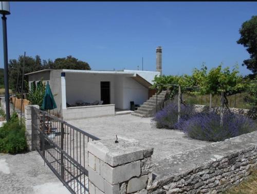 a house with a fence and a stone wall at Apartmani Ino in Škrip